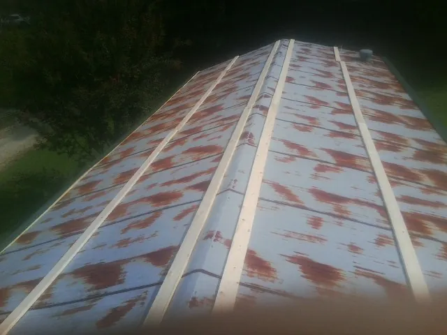 Rusted metal roof panels with new wood purlins before replacement — Storm Damage Roof Repair in Lowell by Roofing Brothers